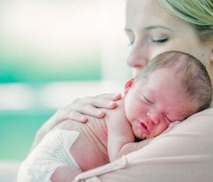 Baby sleeping on mom's shoulder. Baby won't sleep unless held.