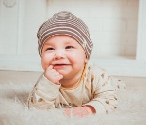 Baby laying on tummy and smiling. Baby registry checklist post.