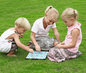 Children playing a game outside. This post is all about how to hire a nanny for twins.