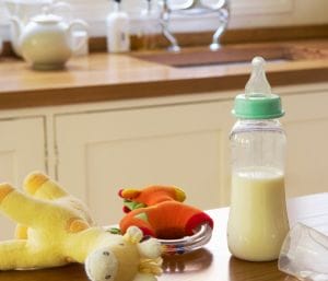 baby bottle and baby toys on kitchen counter