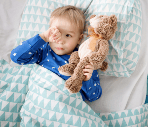 Child awake and laying in bed with a stuffy. This article discusses what to do when your 3-year-old won't go to bed.