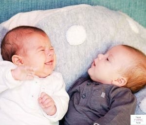 Twin babies lounging on a pillow. This post is all about the best twin feeding pillows.