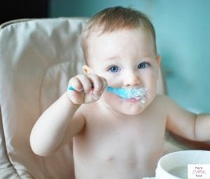 Baby feeding himself baby cereal. This article discusses the oatmeal vs rice cereal for babies and which one is best.