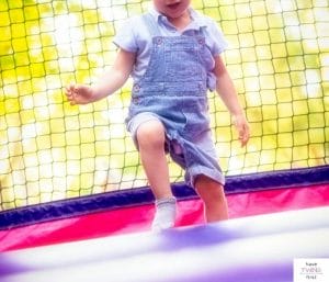 Toddler jumping in a bounce house. This article reviews the best bounce houses for toddlers.