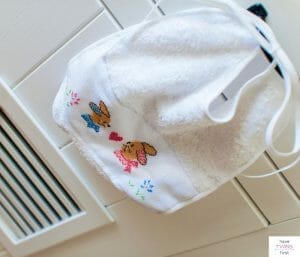 Bib hanging on a cabinet. This article discusses how many bibs and burp cloths are needed for a baby.