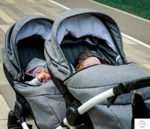 Double tandem stroller with babies inside. This articles discusses the best and coolest things for twins you can buy.