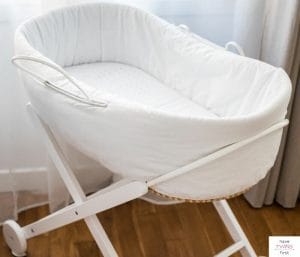 Bassinet set up in a room next to a window. This article discusses the best portable bassinets.