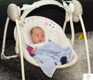 Baby in a compact swing. This article discusses the best baby swings for small spaces.