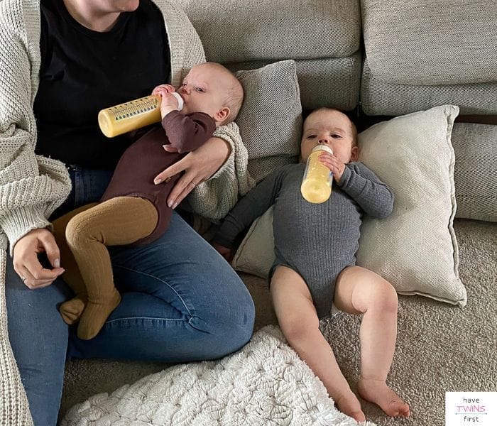 Twins drinking from baby bottles. This article discusses tips for bottle feeding twins.
